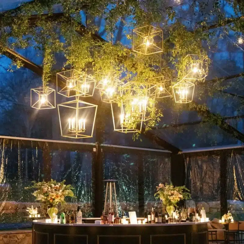 Clear-top tent with hanging geometric lanterns glowing