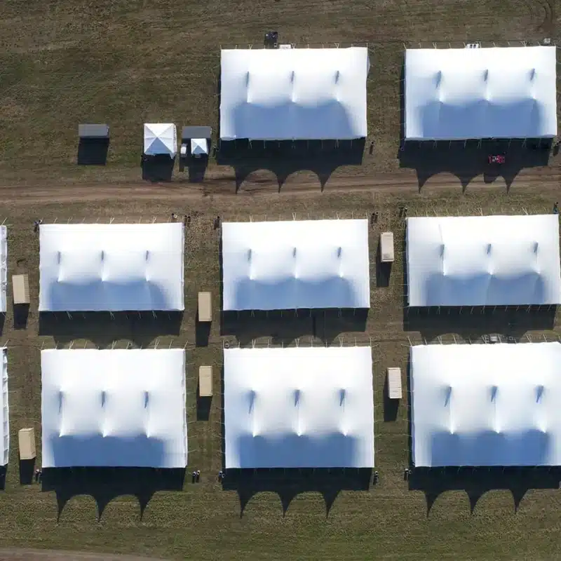 Aerial view of multiple large festival tents arranged in a grid on an open field