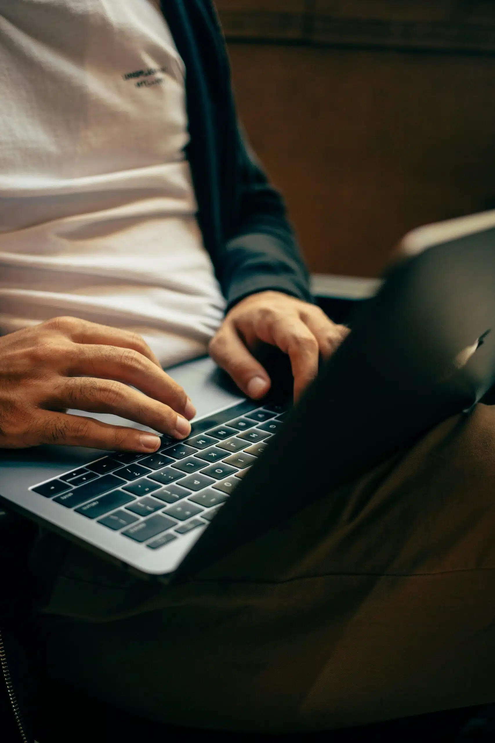 A person typing on a laptop, researching and comparing the best portable tent options for different event needs.