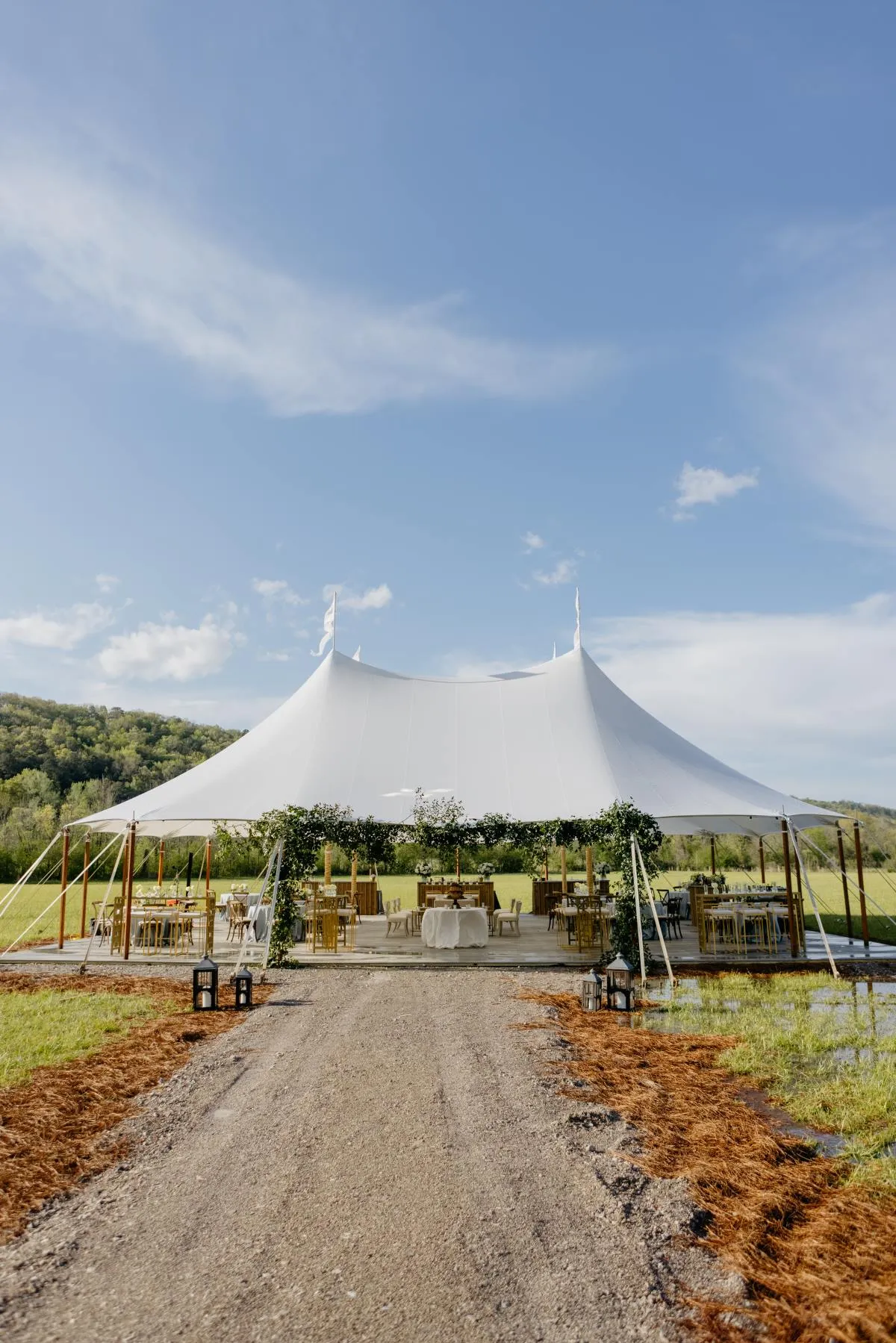 High peak tent with open sides set up for an outdoor event.