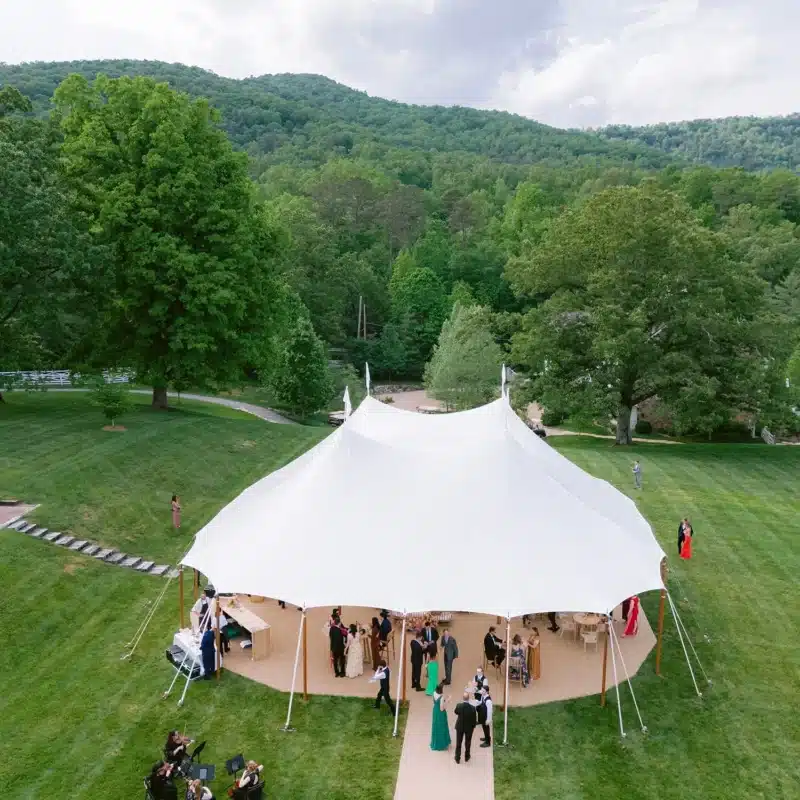 White sailcloth tent wedding with guests on outdoor lawn