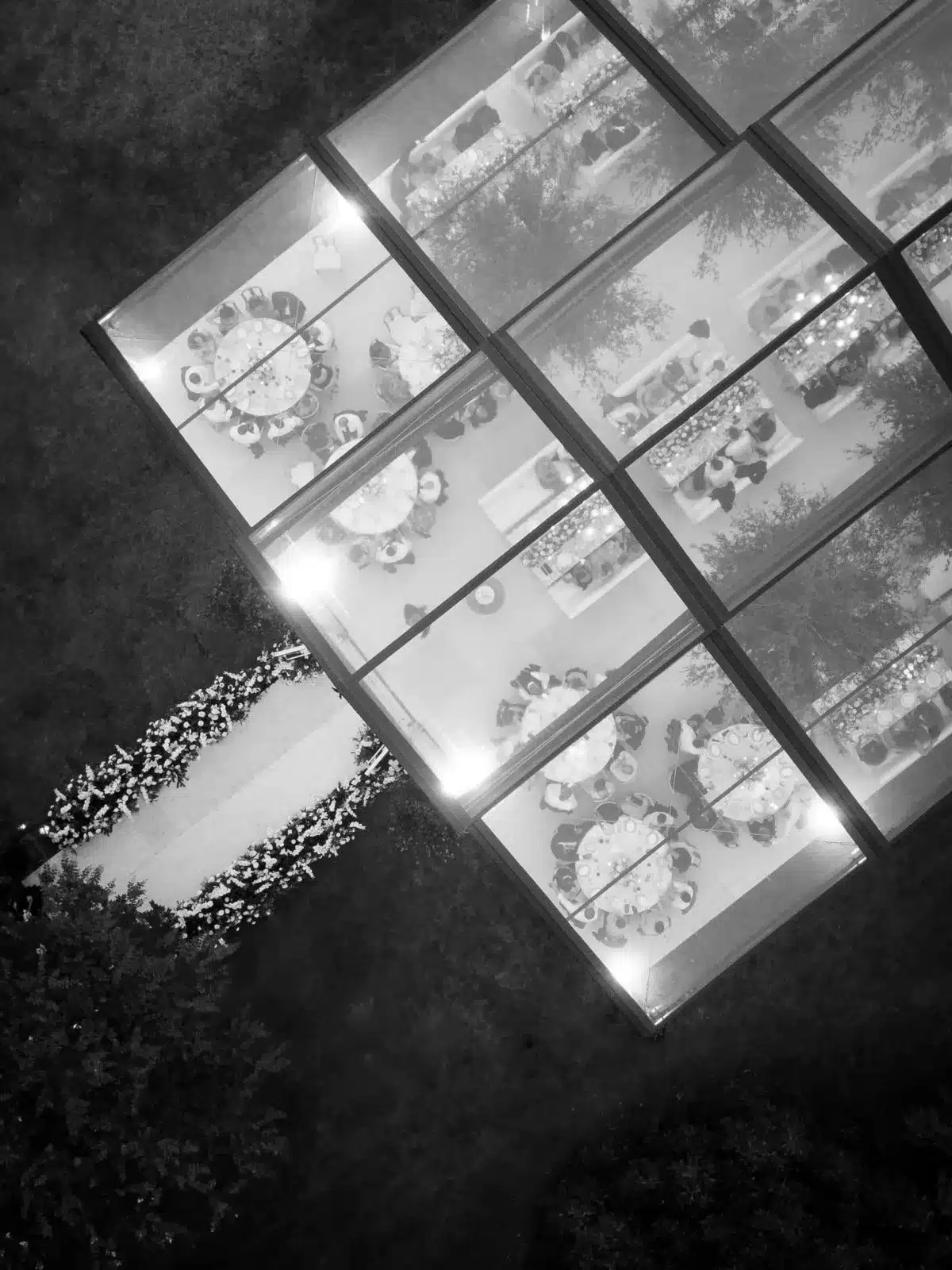 Aerial view of clear tent with round dining tables and wedding aisle