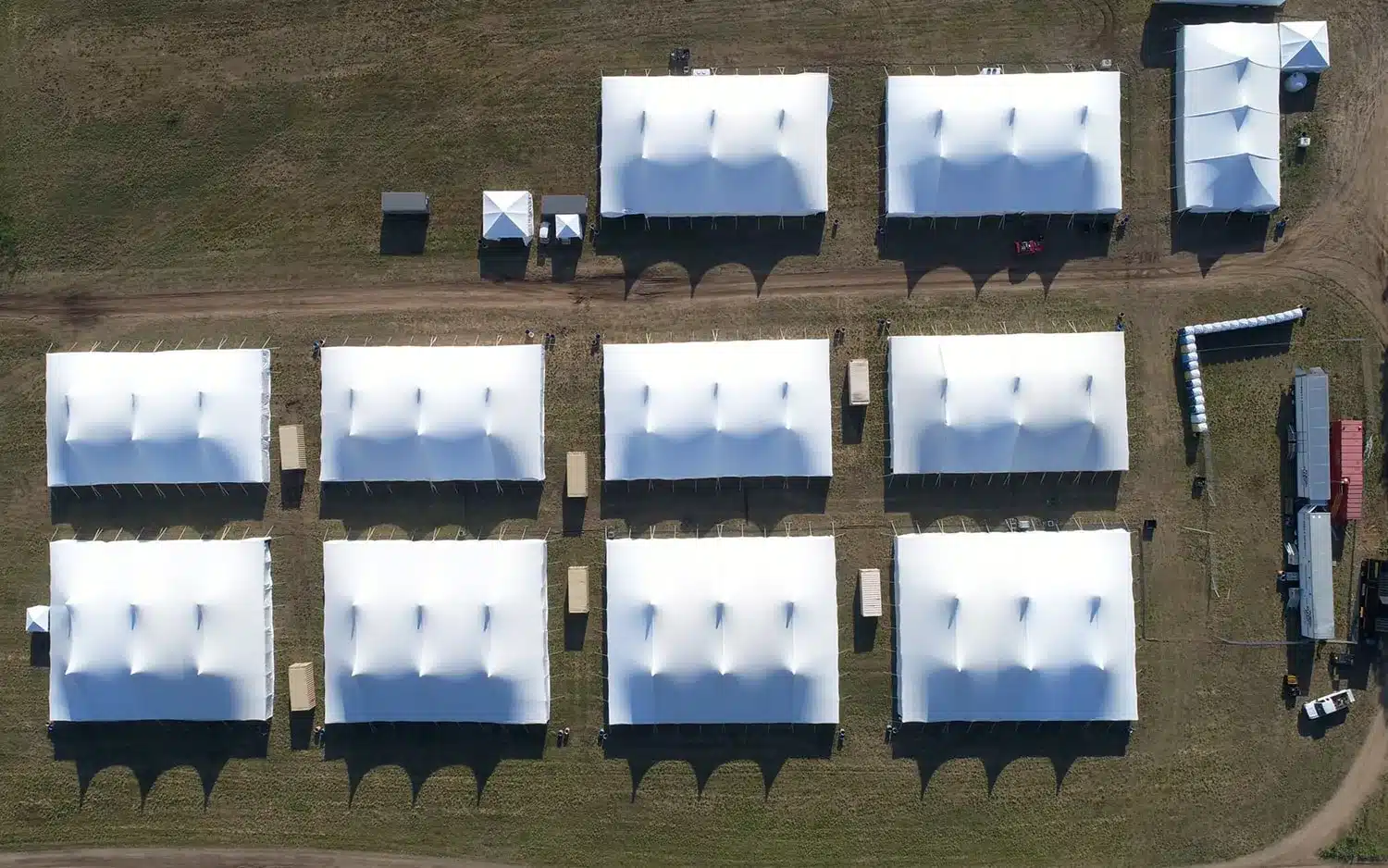 Aerial view of multiple Century Pole Tents arranged in rows on open event grounds.