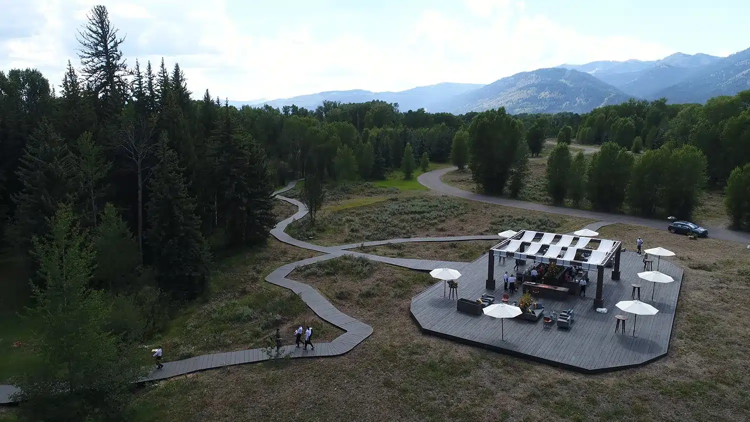 Scenic mountain venue with modern outdoor deck and umbrellas