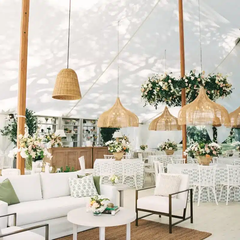 Chic tent interior with floral arrangements and woven pendant lights
