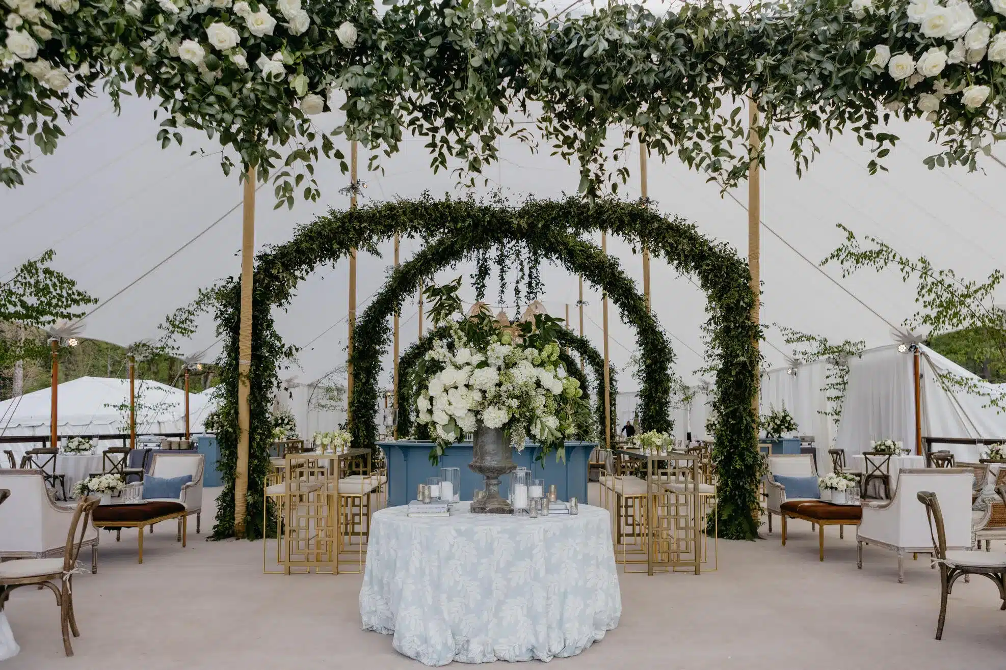 Elegant sailcloth tent interior with floral arches, soft seating, and natural light—showcasing why these structures offer a refined and flexible setting for corporate events.