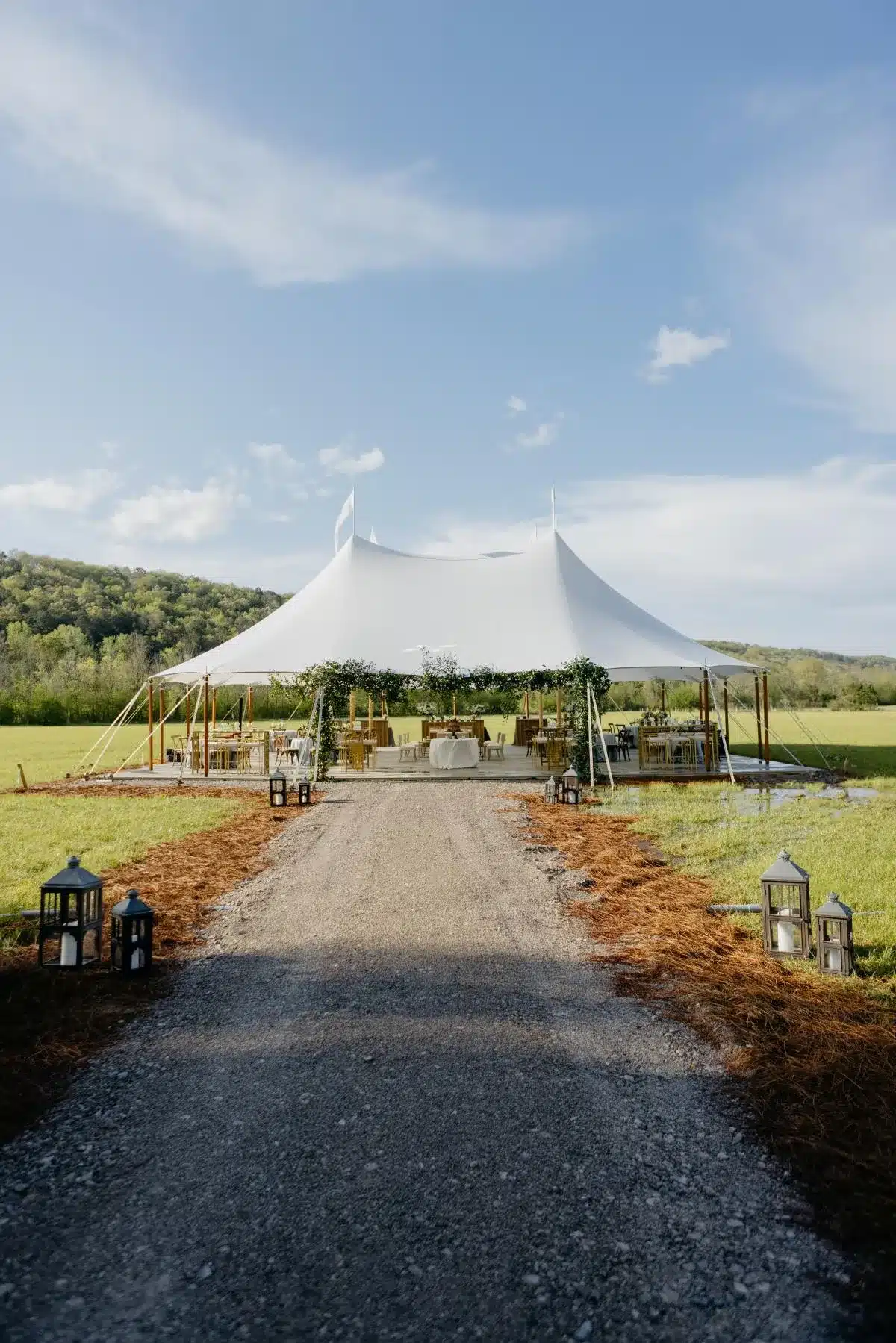 White sailcloth tent with open sides and scenic mountain backdrop