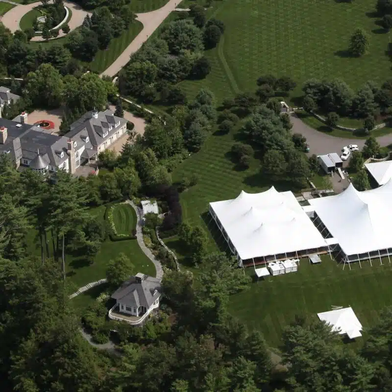 large white event tents installed on an estate lawn for an upscale gathering.