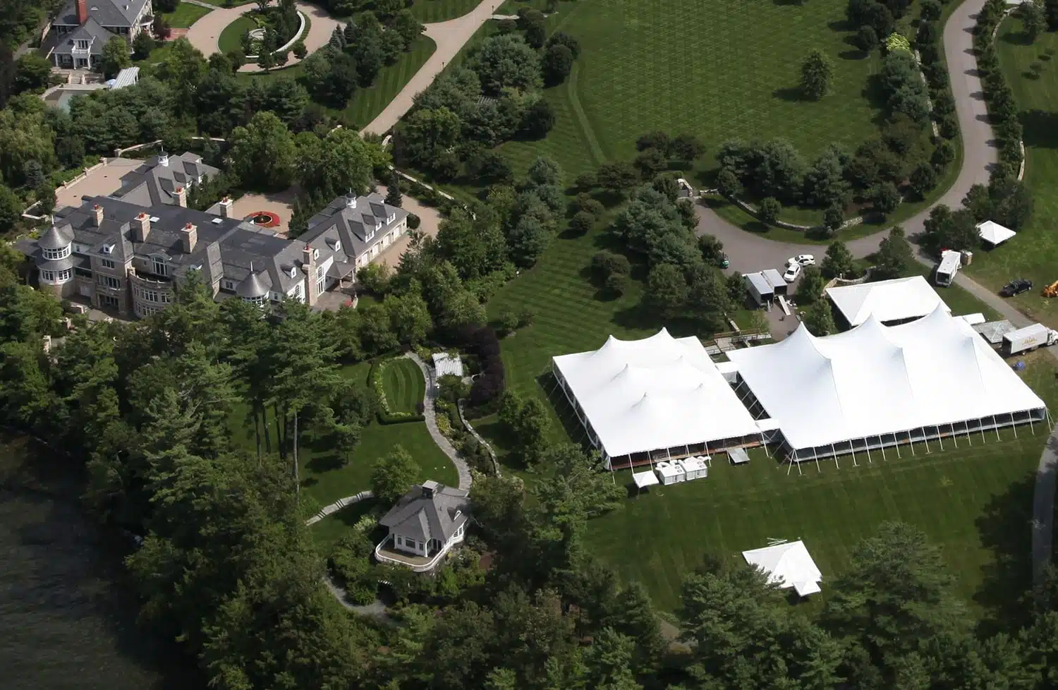 large white event tents installed on an estate lawn for an upscale gathering.