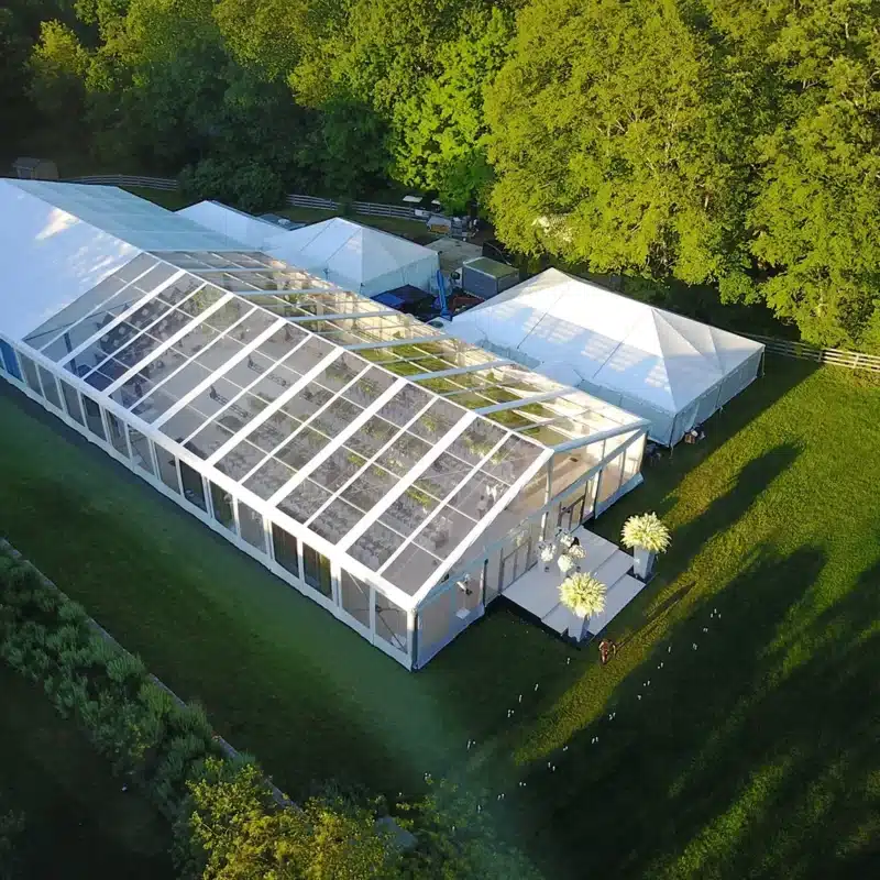 Aerial view of a clear-top backyard party tent with support tents, illustrating proper layout and spacing for an efficient event setup