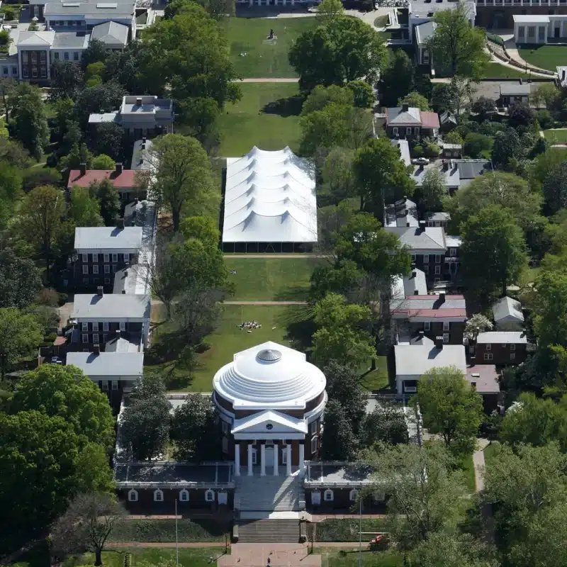 Aerial view of a large white sailcloth backyard tent set up on manicured grounds for a luxury outdoor event