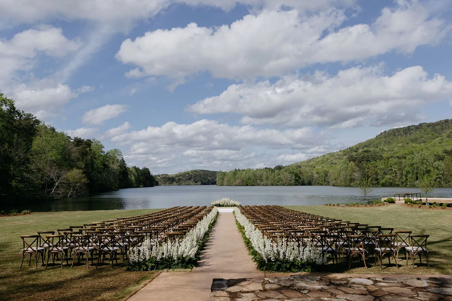 Lakeside ceremony setup on graded lawn showing ground preparation and layout planning for tented wedding