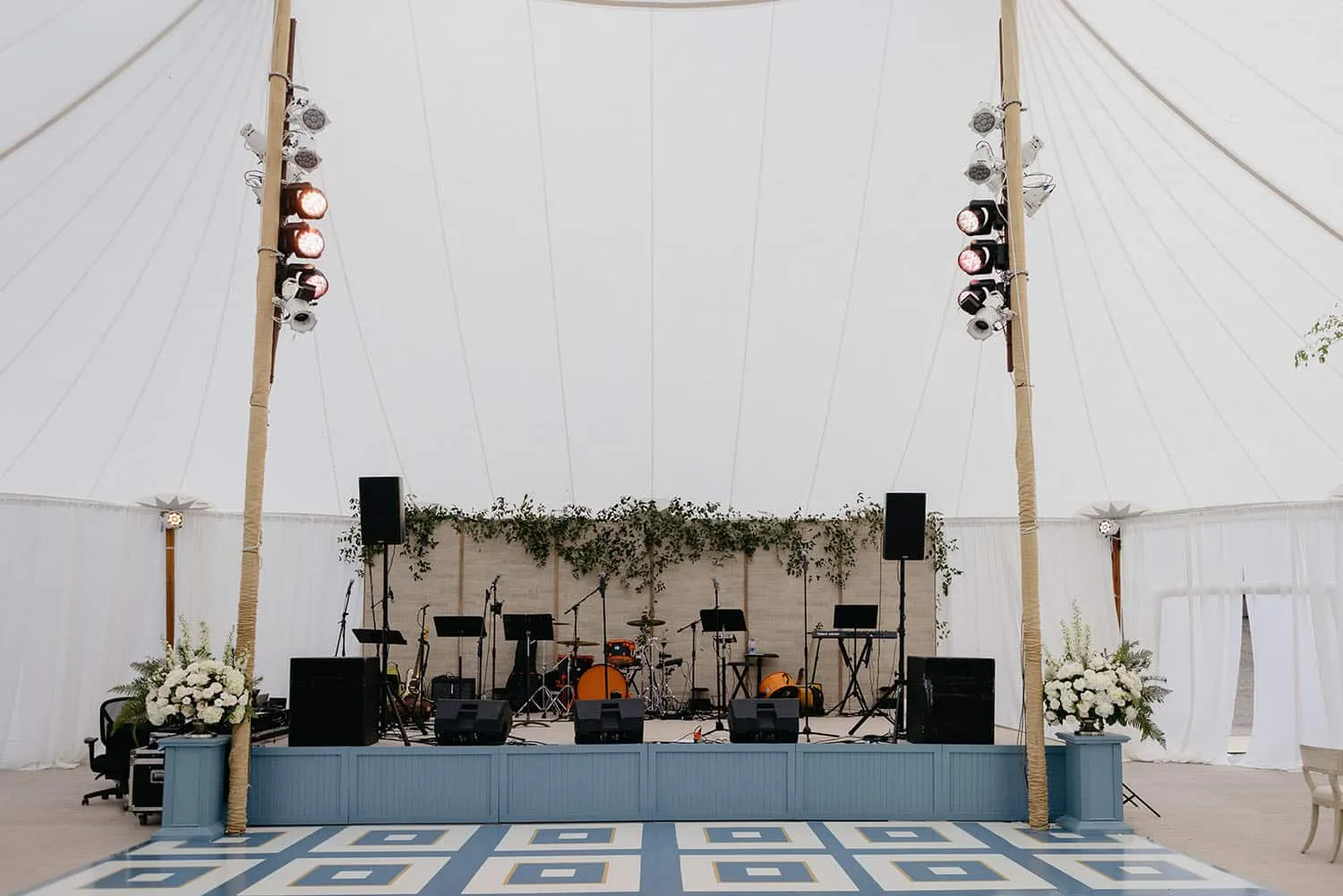 Wedding reception tent stage and lighting setup demonstrating weather-protected entertainment space for beach weddings