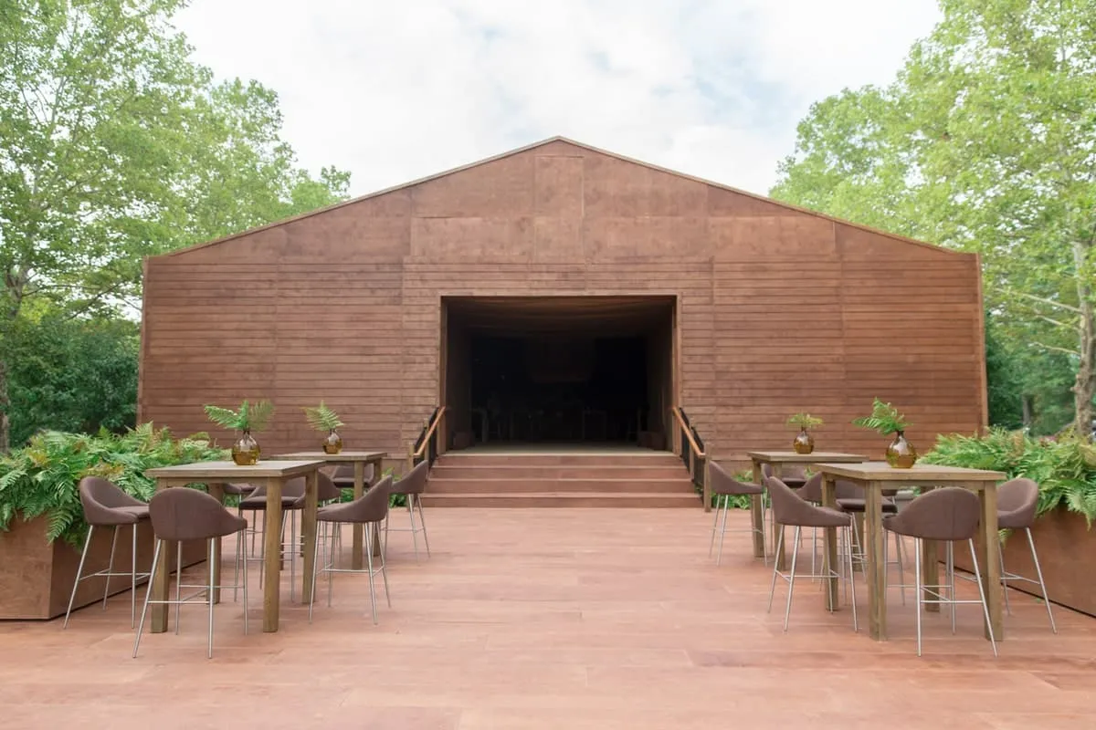 Outdoor wedding tent setup with shaded seating and open entry to promote airflow and reduce heat