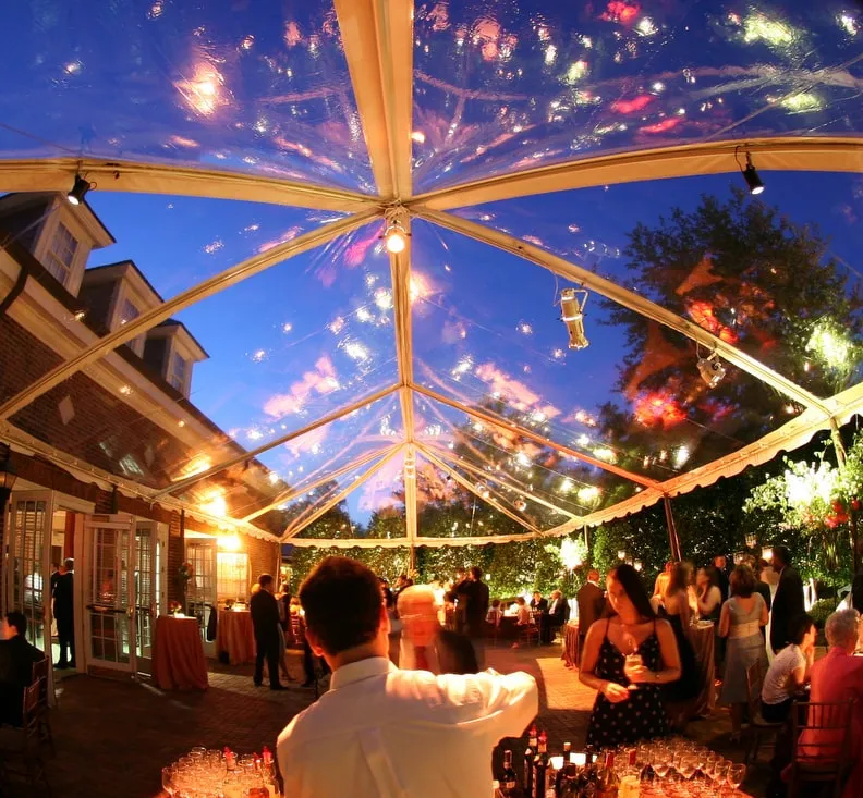 Elegant outdoor tent reception at sunset demonstrating transformation of backyard into luxury summer wedding venue