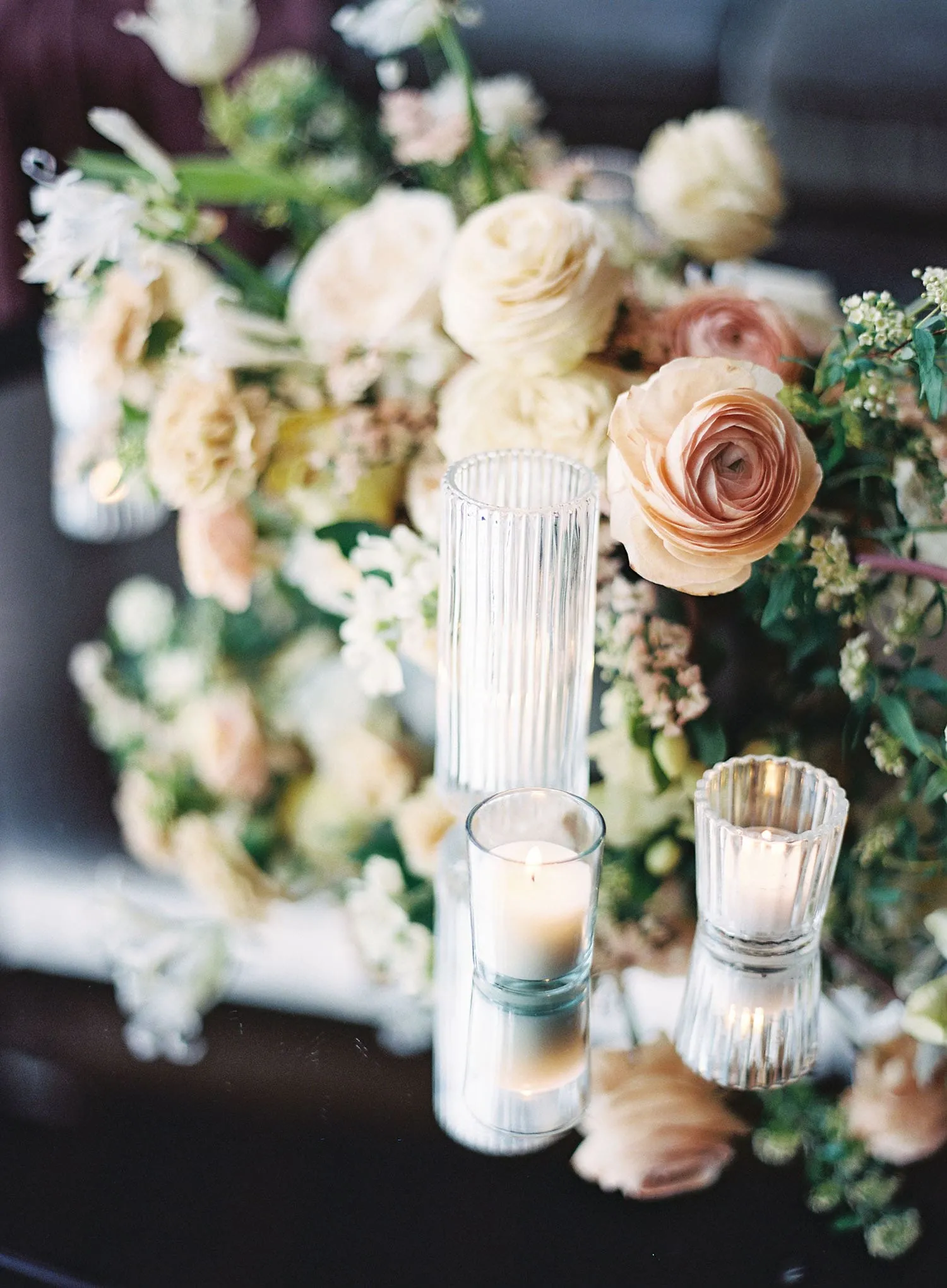 Wedding table décor with candles and florals highlighting elegant design elements used near a summer wedding tent entrance