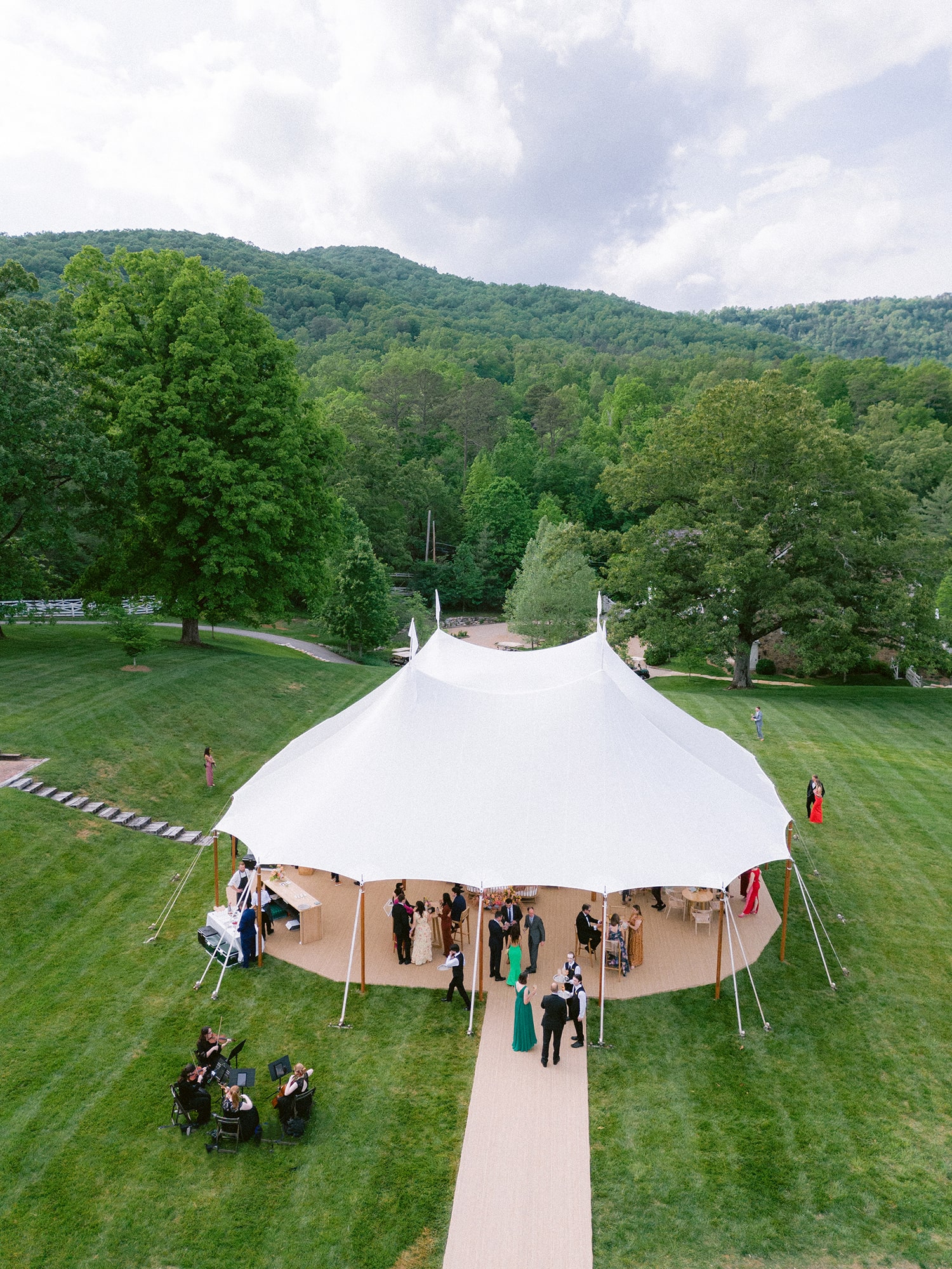 Outdoor corporate tent for summer event with lighting and lounge areas
